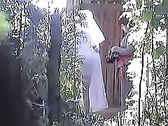 Well-bodied brunette in short skirt decided that she was absolutely alone behind that huge tree, so she took off her pants and began to pee